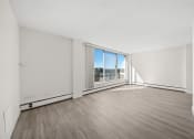 Thumbnail 14 of 33 - an empty living room with wood flooring and a large window