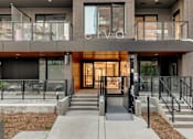 Thumbnail 73 of 78 - A modern building with a glass entrance and a staircase leading to it.