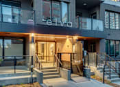 Thumbnail 71 of 78 - The entrance to a modern building with a glass door and a staircase leading up to it.