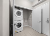 Thumbnail 13 of 25 - a white washer and dryer in a laundry room with a white door