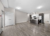 Thumbnail 14 of 25 - the living room and kitchen in a new home with white walls and wood flooring