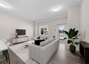 Thumbnail 3 of 25 - a living room with a white couch and a table and a television