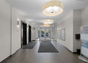 Thumbnail 16 of 72 - a hallway with doors and rugs in a building with white walls