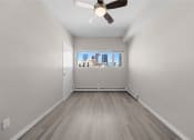 Thumbnail 47 of 48 - an empty living room with a ceiling fan and a window