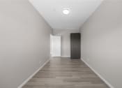 Thumbnail 36 of 48 - a long hallway with white walls and wood floors and a closet