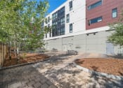 Thumbnail 28 of 48 - a courtyard with benches and trees in front of a building