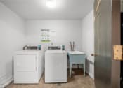 Thumbnail 33 of 37 - two washing machines and a sink in a laundry room with a door