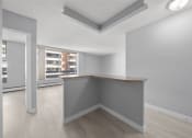 Thumbnail 17 of 33 - the living room and kitchen of an apartment with grey walls and wood flooring