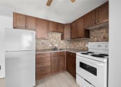 Thumbnail 10 of 33 - an empty kitchen with white appliances and wooden cabinets