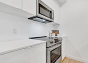 Thumbnail 52 of 78 - A modern kitchen with a stainless steel oven and microwave.