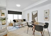 Thumbnail 13 of 78 - A living room with a black table and chairs.