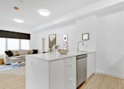 Thumbnail 26 of 78 - A modern kitchen with white appliances and a white countertop.