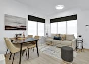 Thumbnail 42 of 78 - A modern living room with a dining table and a couch.