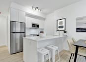 Thumbnail 48 of 78 - A modern kitchen with white cabinets and a stainless steel refrigerator.