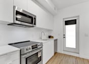 Thumbnail 9 of 78 - A kitchen with white appliances and cabinets.