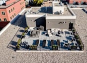 Thumbnail 74 of 78 - A rooftop patio with a table and chairs.