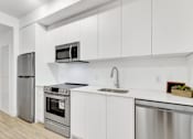 Thumbnail 10 of 78 - A modern kitchen with white cabinets and stainless steel appliances.
