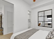 Thumbnail 3 of 78 - A bedroom with a large bed and a window with a view of a living room.