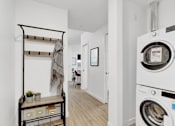 Thumbnail 11 of 78 - A white washing machine is in a small laundry room.