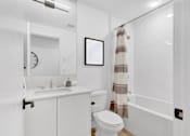 Thumbnail 5 of 78 - A white bathroom with a toilet, sink, and bathtub.