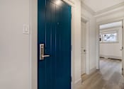 Thumbnail 75 of 219 - A blue door with a silver handle in a white hallway.