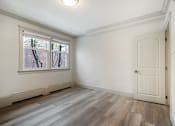 Thumbnail 65 of 219 - A room with a white door and a window with a view of trees.