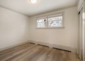 Thumbnail 62 of 219 - A room with a window and wooden flooring.