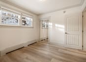 Thumbnail 61 of 219 - A room with a white door and a window showing a snowy scene outside.