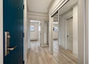 Thumbnail 74 of 219 - A hallway with a blue door and a mirror on the wall.