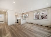 Thumbnail 32 of 219 - A spacious kitchen with wooden flooring and white walls.