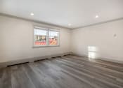 Thumbnail 54 of 219 - A room with a window and wooden flooring.