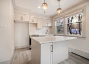 Thumbnail 29 of 219 - A kitchen with white cabinets and a marble countertop.