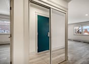 Thumbnail 72 of 219 - A room with a teal door and a white wall.