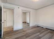 Thumbnail 44 of 219 - A room with a wooden floor and white walls.