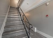 Thumbnail 207 of 219 - A staircase with a metal railing and grey steps.
