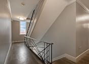 Thumbnail 204 of 219 - A staircase with a metal railing and wooden steps.