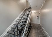Thumbnail 202 of 219 - A staircase with a metal railing and wooden steps.