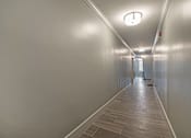 Thumbnail 200 of 219 - A long hallway with a light on the ceiling and a door at the end.