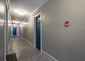 Thumbnail 198 of 219 - A hallway with a blue door and a red sign on the wall.