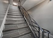 Thumbnail 196 of 219 - A staircase with a metal railing and stone steps.