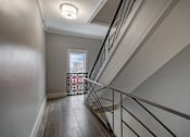 Thumbnail 195 of 219 - A staircase with a metal railing and a window in the background.