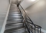 Thumbnail 193 of 219 - A staircase with a metal railing and wooden steps.