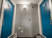 Thumbnail 188 of 219 - A hallway with blue doors numbered 10 and 11.