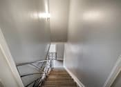 Thumbnail 185 of 219 - A staircase with a metal railing and wooden steps.