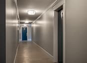 Thumbnail 212 of 219 - A long hallway with a blue door at the end.