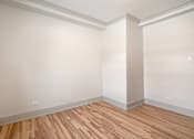 Thumbnail 173 of 219 - A room with wooden flooring and white walls.