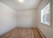 Thumbnail 167 of 219 - Empty room with wooden floor and a window.