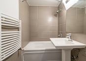 Thumbnail 165 of 219 - A white bathroom with a white tub and sink.