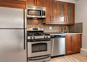 Thumbnail 183 of 219 - A modern kitchen with a stainless steel refrigerator, oven, and microwave.