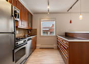 Thumbnail 179 of 219 - A kitchen with wooden cabinets and stainless steel appliances.